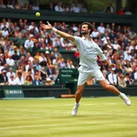 Professional tennis player serving ball during match