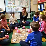 Children learning budgeting with piggy banks